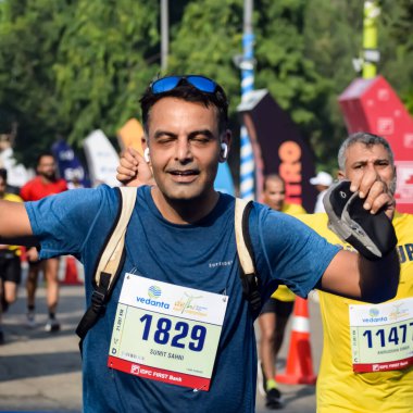 Yeni Delhi, Hindistan - 15 Ekim 2023 - Bitmek üzere olan maraton katılımcılarının bitiş çizgisini geçmek üzere olan Delhi Yarı Maratonu 2023