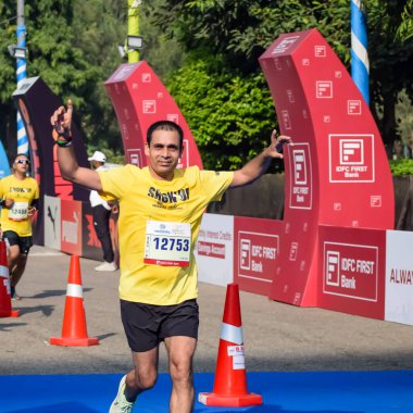 Yeni Delhi, Hindistan - 15 Ekim 2023 - Bitmek üzere olan maraton katılımcılarının bitiş çizgisini geçmek üzere olan Delhi Yarı Maratonu 2023