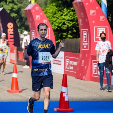 Yeni Delhi, Hindistan - 15 Ekim 2023 - Bitmek üzere olan maraton katılımcılarının bitiş çizgisini geçmek üzere olan Delhi Yarı Maratonu 2023