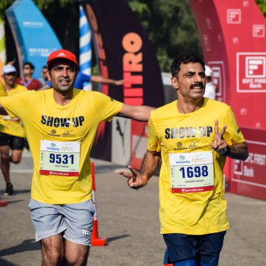 Yeni Delhi, Hindistan - 15 Ekim 2023 - Bitmek üzere olan maraton katılımcılarının bitiş çizgisini geçmek üzere olan Delhi Yarı Maratonu 2023