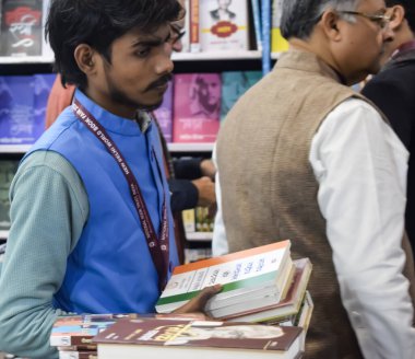 Delhi, Hindistan, 17 Şubat 2024 - Çeşitli yaş gruplarından insanlar Delhi Uluslararası Kitap Fuarı 'ndaki bir kitapçıda çeşitli kitaplar okuyor, Bharat Mandapam kompleksindeki Yıllık Kitap Fuarı' nda kitaplar