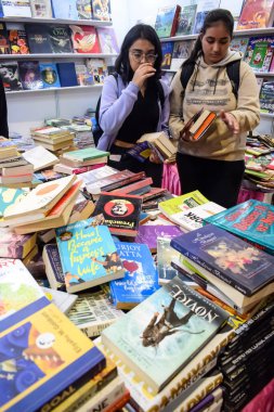 Delhi, Hindistan, 17 Şubat 2024 - Çeşitli yaş gruplarından insanlar Delhi Uluslararası Kitap Fuarı 'ndaki bir kitapçıda çeşitli kitaplar okuyor, Bharat Mandapam kompleksindeki Yıllık Kitap Fuarı' nda kitaplar