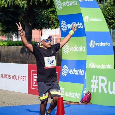 Yeni Delhi, Hindistan - 15 Ekim 2023 - Bitmek üzere olan maraton katılımcılarının bitiş çizgisini geçmek üzere olan Delhi Yarı Maratonu 2023
