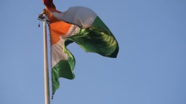India flag flying high at Connaught Place with pride in blue sky, India flag fluttering, Indian Flag on Independence Day and Republic Day of India, tilt up shot, Waving Indian flag, Har Ghar Tiranga