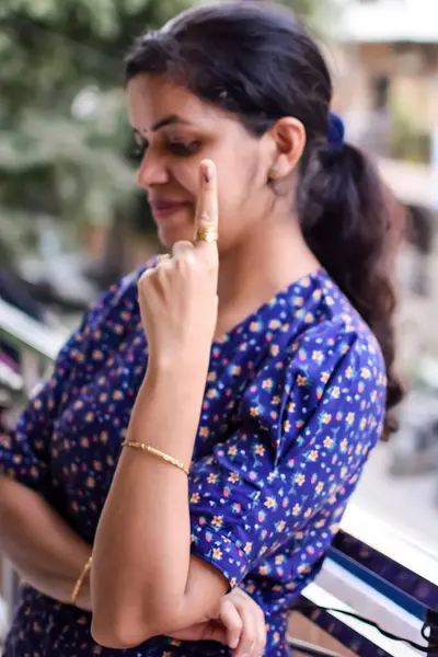 stock image Smart young lady showing her ink-marked fingers after casting votes in front of polling booth of east Delhi area for general Lok Sabha Elections 2024