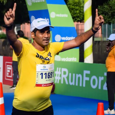 Yeni Delhi, Hindistan - 15 Ekim 2023 - Bitmek üzere olan maraton katılımcılarının bitiş çizgisini geçmek üzere olan Delhi Yarı Maratonu 2023