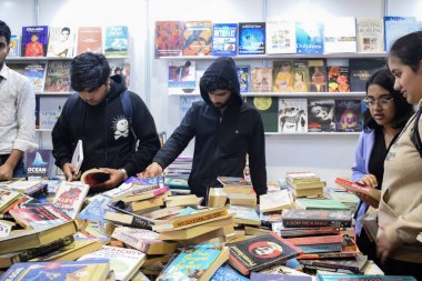 Delhi, Hindistan, 17 Şubat 2024 - Çeşitli yaş gruplarından insanlar Delhi Uluslararası Kitap Fuarı 'ndaki bir kitapçıda çeşitli kitaplar okuyor, Bharat Mandapam kompleksindeki Yıllık Kitap Fuarı' nda kitaplar
