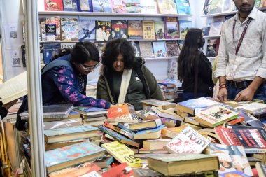 Delhi, Hindistan, 17 Şubat 2024 - Çeşitli yaş gruplarından insanlar Delhi Uluslararası Kitap Fuarı 'ndaki bir kitapçıda çeşitli kitaplar okuyor, Bharat Mandapam kompleksindeki Yıllık Kitap Fuarı' nda kitaplar