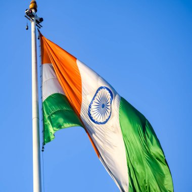India flag flying high at Connaught Place with pride in blue sky, India flag fluttering, Indian Flag on Independence Day and Republic Day of India, tilt up shot, Waving Indian flag, Har Ghar Tiranga