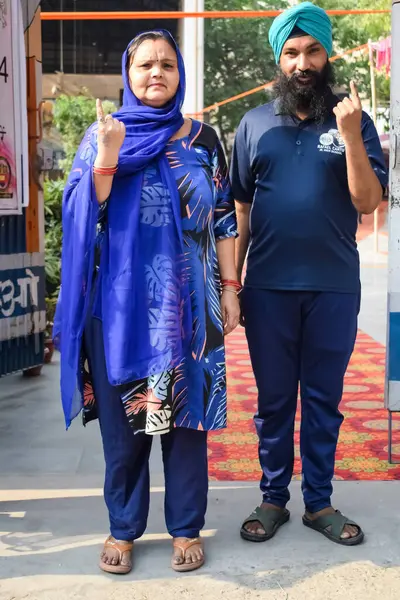 stock image New Delhi, India - May 25 2024 - Unidentified people showing their ink-marked fingers after casting votes in front of polling booth of east Delhi area for general Lok Sabha Elections 2024