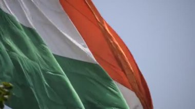 India flag flying high at Connaught Place with pride in blue sky, India flag fluttering, Indian Flag on Independence Day and Republic Day of India, tilt up shot, Waving Indian flag, Har Ghar Tiranga