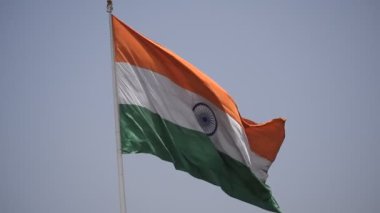 India flag flying high at Connaught Place with pride in blue sky, India flag fluttering, Indian Flag on Independence Day and Republic Day of India, tilt up shot, Waving Indian flag, Har Ghar Tiranga