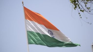 India flag flying high at Connaught Place with pride in blue sky, India flag fluttering, Indian Flag on Independence Day and Republic Day of India, tilt up shot, Waving Indian flag, Har Ghar Tiranga