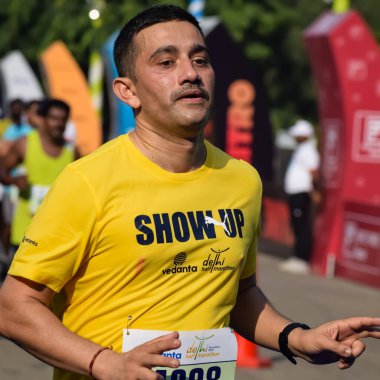 Yeni Delhi, Hindistan - 15 Ekim 2023 - Bitmek üzere olan maraton katılımcılarının bitiş çizgisini geçmek üzere olan Delhi Yarı Maratonu 2023