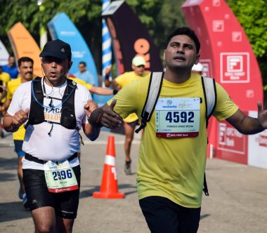 Yeni Delhi, Hindistan - 15 Ekim 2023 - Bitmek üzere olan maraton katılımcılarının bitiş çizgisini geçmek üzere olan Delhi Yarı Maratonu 2023