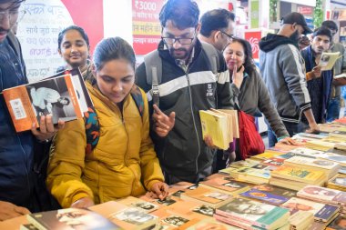 Delhi, Hindistan, 17 Şubat 2024 - Çeşitli yaş gruplarından insanlar Delhi Uluslararası Kitap Fuarı 'ndaki bir kitapçıda çeşitli kitaplar okuyor, Bharat Mandapam kompleksindeki Yıllık Kitap Fuarı' nda kitaplar