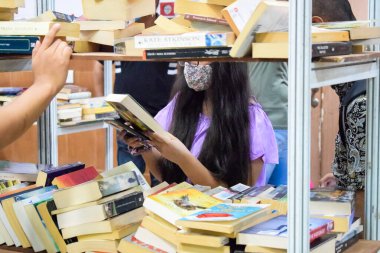 Delhi, Hindistan, 17 Şubat 2024 - Çeşitli yaş gruplarından insanlar Delhi Uluslararası Kitap Fuarı 'ndaki bir kitapçıda çeşitli kitaplar okuyor, Bharat Mandapam kompleksindeki Yıllık Kitap Fuarı' nda kitaplar