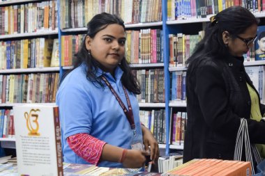 Delhi, Hindistan, 17 Şubat 2024 - Çeşitli yaş gruplarından insanlar Delhi Uluslararası Kitap Fuarı 'ndaki bir kitapçıda çeşitli kitaplar okuyor, Bharat Mandapam kompleksindeki Yıllık Kitap Fuarı' nda kitaplar