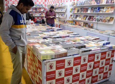 Delhi, Hindistan, 17 Şubat 2024 - Çeşitli yaş gruplarından insanlar Delhi Uluslararası Kitap Fuarı 'ndaki bir kitapçıda çeşitli kitaplar okuyor, Bharat Mandapam kompleksindeki Yıllık Kitap Fuarı' nda kitaplar