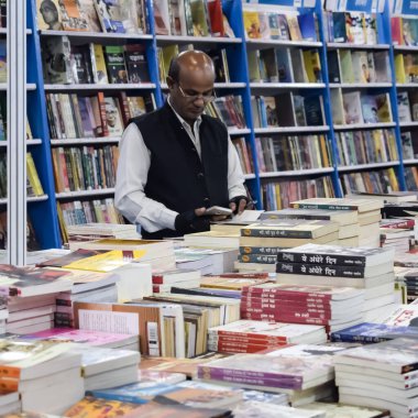 Delhi, Hindistan, 17 Şubat 2024 - Çeşitli yaş gruplarından insanlar Delhi Uluslararası Kitap Fuarı 'ndaki bir kitapçıda çeşitli kitaplar okuyor, Bharat Mandapam kompleksindeki Yıllık Kitap Fuarı' nda kitaplar