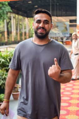 Yeni Delhi, Hindistan - 25 Mayıs 2024 - Doğu Delhi bölgesindeki genel Lok Sabha Seçimleri için oy kullandıktan sonra dövmeli parmaklarını gösteren kimliği belirsiz kişiler