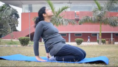 Young Indian woman practicing yoga outdoor in a park. Beautiful girl practice basic yoga pose. Calmness and relax, female happiness. Basic Yoga poses outdoor 