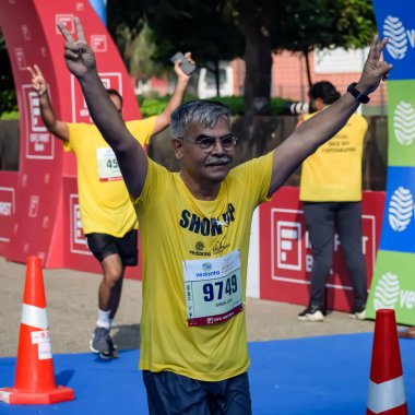 Yeni Delhi, Hindistan - 15 Ekim 2023 - Bitmek üzere olan maraton katılımcılarının bitiş çizgisini geçmek üzere olan Delhi Yarı Maratonu 2023