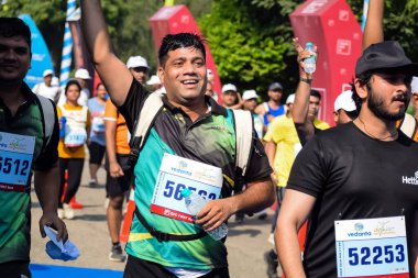 Yeni Delhi, Hindistan - 15 Ekim 2023 - Bitmek üzere olan maraton katılımcılarının bitiş çizgisini geçmek üzere olan Delhi Yarı Maratonu 2023