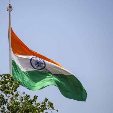 India flag flying high at Connaught Place with pride in blue sky, India flag fluttering, Indian Flag on Independence Day and Republic Day of India, tilt up shot, Waving Indian flag, Har Ghar Tiranga