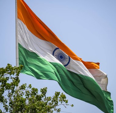 India flag flying high at Connaught Place with pride in blue sky, India flag fluttering, Indian Flag on Independence Day and Republic Day of India, tilt up shot, Waving Indian flag, Har Ghar Tiranga