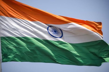 India flag flying high at Connaught Place with pride in blue sky, India flag fluttering, Indian Flag on Independence Day and Republic Day of India, tilt up shot, Waving Indian flag, Har Ghar Tiranga