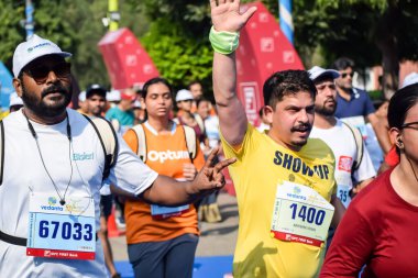 Yeni Delhi, Hindistan - 15 Ekim 2023 - Bitmek üzere olan maraton katılımcılarının bitiş çizgisini geçmek üzere olan Delhi Yarı Maratonu 2023