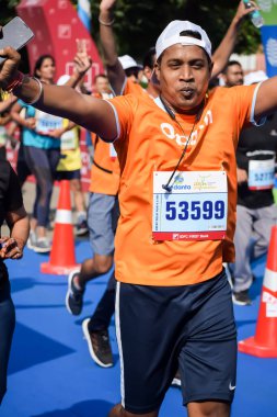 Yeni Delhi, Hindistan - 15 Ekim 2023 - Bitmek üzere olan maraton katılımcılarının bitiş çizgisini geçmek üzere olan Delhi Yarı Maratonu 2023