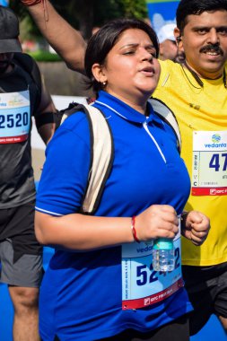 Yeni Delhi, Hindistan - 15 Ekim 2023 - Bitmek üzere olan maraton katılımcılarının bitiş çizgisini geçmek üzere olan Delhi Yarı Maratonu 2023