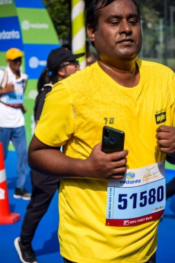 Yeni Delhi, Hindistan - 15 Ekim 2023 - Bitmek üzere olan maraton katılımcılarının bitiş çizgisini geçmek üzere olan Delhi Yarı Maratonu 2023