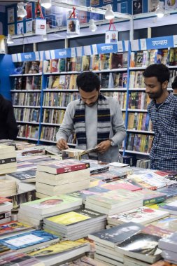 Delhi, Hindistan, 17 Şubat 2024 - Çeşitli yaş gruplarından insanlar Delhi Uluslararası Kitap Fuarı 'ndaki bir kitapçıda çeşitli kitaplar okuyor, Bharat Mandapam kompleksindeki Yıllık Kitap Fuarı' nda kitaplar