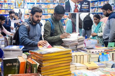 Delhi, Hindistan, 17 Şubat 2024 - Çeşitli yaş gruplarından insanlar Delhi Uluslararası Kitap Fuarı 'ndaki bir kitapçıda çeşitli kitaplar okuyor, Bharat Mandapam kompleksindeki Yıllık Kitap Fuarı' nda kitaplar