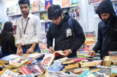 Delhi, Hindistan, 17 Şubat 2024 - Çeşitli yaş gruplarından insanlar Delhi Uluslararası Kitap Fuarı 'ndaki bir kitapçıda çeşitli kitaplar okuyor, Bharat Mandapam kompleksindeki Yıllık Kitap Fuarı' nda kitaplar