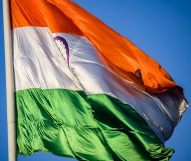 India flag flying high at Connaught Place with pride in blue sky, India flag fluttering, Indian Flag on Independence Day and Republic Day of India, tilt up shot, Waving Indian flag, Har Ghar Tiranga