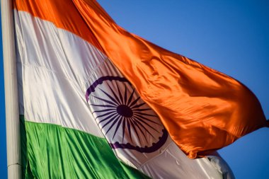 India flag flying high at Connaught Place with pride in blue sky, India flag fluttering, Indian Flag on Independence Day and Republic Day of India, tilt up shot, Waving Indian flag, Har Ghar Tiranga