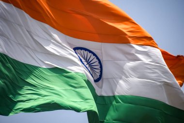 India flag flying high at Connaught Place with pride in blue sky, India flag fluttering, Indian Flag on Independence Day and Republic Day of India, tilt up shot, Waving Indian flag, Har Ghar Tiranga