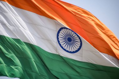 India flag flying high at Connaught Place with pride in blue sky, India flag fluttering, Indian Flag on Independence Day and Republic Day of India, tilt up shot, Waving Indian flag, Har Ghar Tiranga