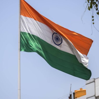 India flag flying high at Connaught Place with pride in blue sky, India flag fluttering, Indian Flag on Independence Day and Republic Day of India, tilt up shot, Waving Indian flag, Har Ghar Tiranga