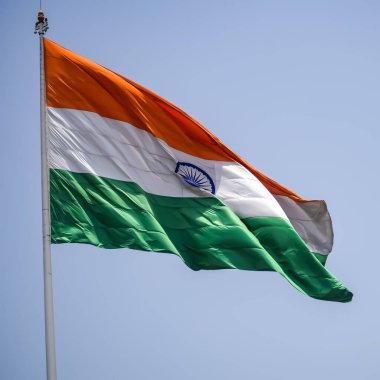 India flag flying high at Connaught Place with pride in blue sky, India flag fluttering, Indian Flag on Independence Day and Republic Day of India, tilt up shot, Waving Indian flag, Har Ghar Tiranga