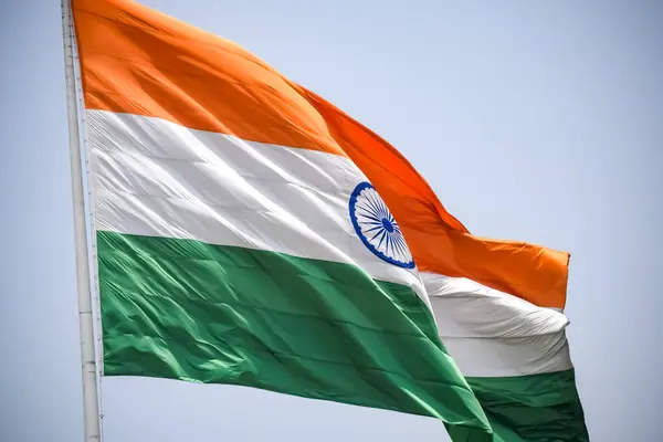 Stock image India flag flying high at Connaught Place with pride in blue sky, India flag fluttering, Indian Flag on Independence Day and Republic Day of India, tilt up shot, Waving Indian flag, Har Ghar Tiranga