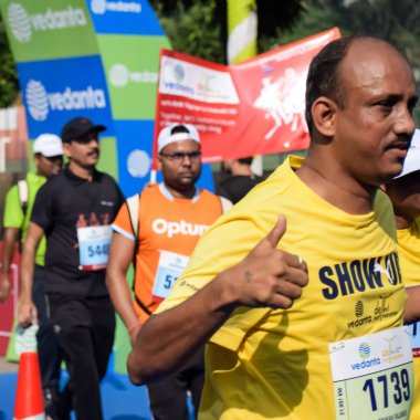 Yeni Delhi, Hindistan - 15 Ekim 2023 - Bitmek üzere olan maraton katılımcılarının bitiş çizgisini geçmek üzere olan Delhi Yarı Maratonu 2023