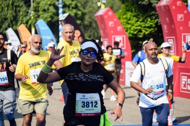 Yeni Delhi, Hindistan - 15 Ekim 2023 - Bitmek üzere olan maraton katılımcılarının bitiş çizgisini geçmek üzere olan Delhi Yarı Maratonu 2023