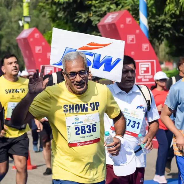 Yeni Delhi, Hindistan - 15 Ekim 2023 - Bitmek üzere olan maraton katılımcılarının bitiş çizgisini geçmek üzere olan Delhi Yarı Maratonu 2023