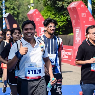 Yeni Delhi, Hindistan - 15 Ekim 2023 - Bitmek üzere olan maraton katılımcılarının bitiş çizgisini geçmek üzere olan Delhi Yarı Maratonu 2023