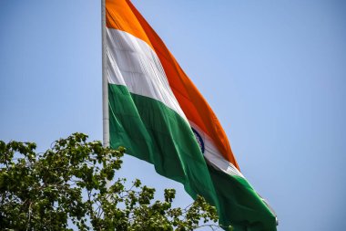 India flag flying high at Connaught Place with pride in blue sky, India flag fluttering, Indian Flag on Independence Day and Republic Day of India, tilt up shot, Waving Indian flag, Har Ghar Tiranga